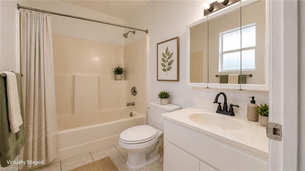 Bathroom featuring a white vanity with a single basin sink, matte black faucet, and a wall-mounted mirrored medicine cabinet