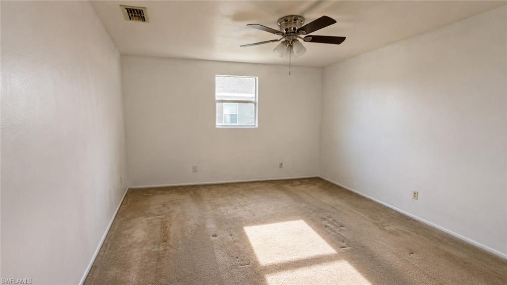 Room featuring light-colored carpeting, white walls, and a single window