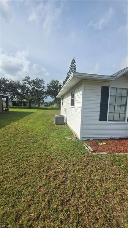 Exterior side of the residence featuring white horizontal siding, dark window shutters, and a sloped roofline