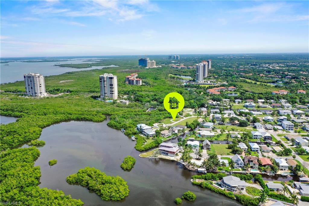 Aerial perspective showcasing a coastal neighborhood with waterways and extensive green space