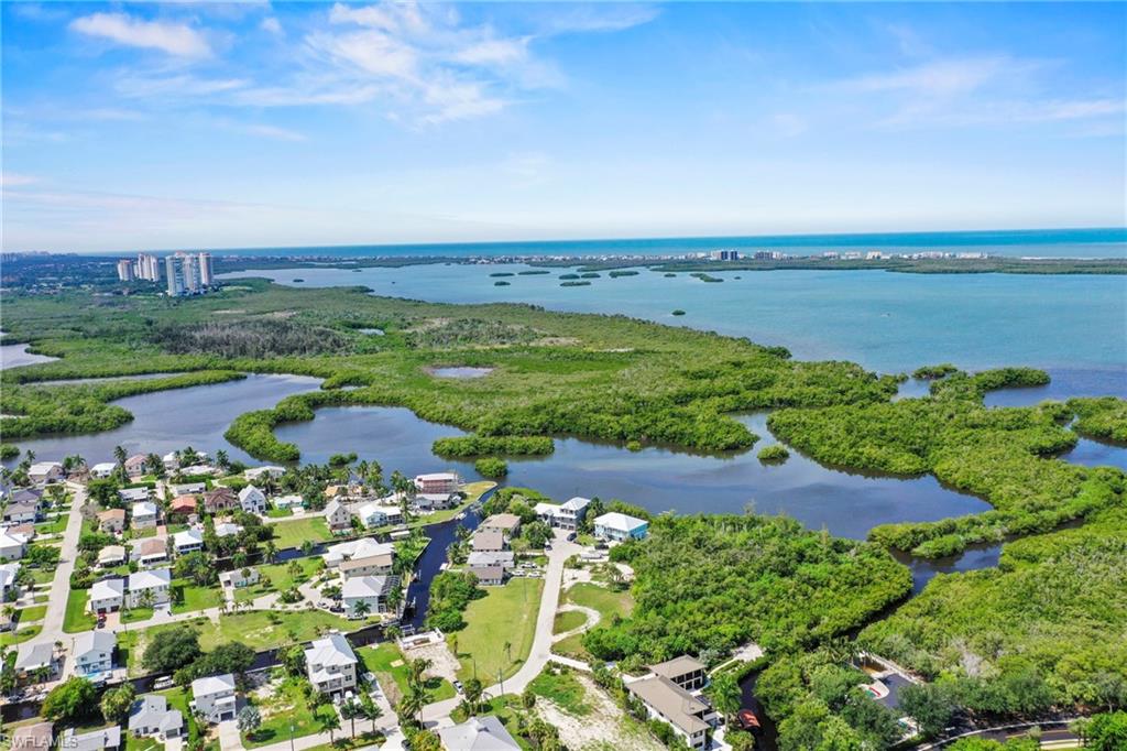 Aerial perspective showcasing a coastal community with numerous residential properties, canals, and abundant green space