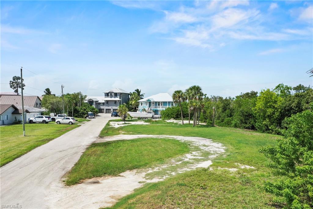 Expansive grass lot with mature trees, offering a clear development opportunity