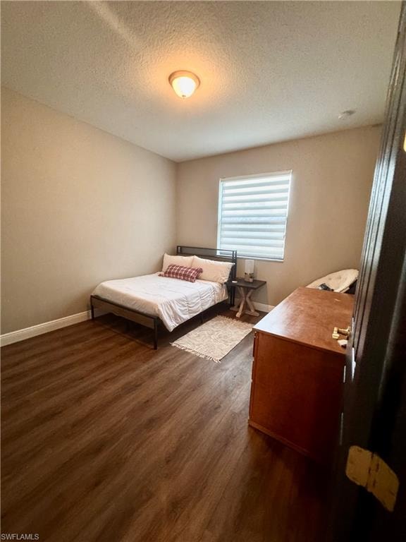 Room featuring wood-finish flooring, a single window with horizontal blinds, and a flush-mount ceiling light fixture