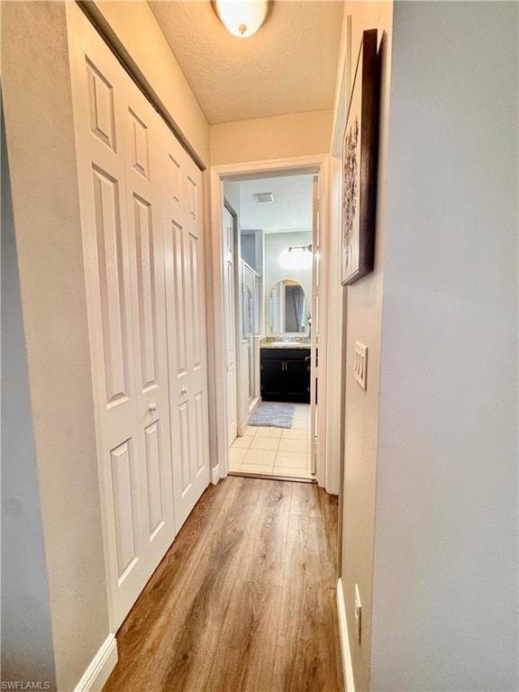 Hallway featuring wood-finish flooring and bi-fold closet doors