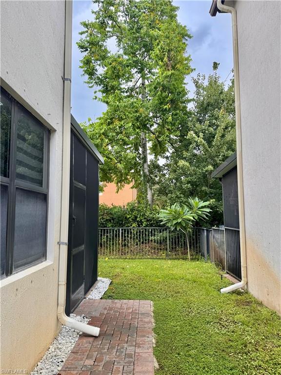 Private outdoor space featuring mature trees and a brick paver pathway