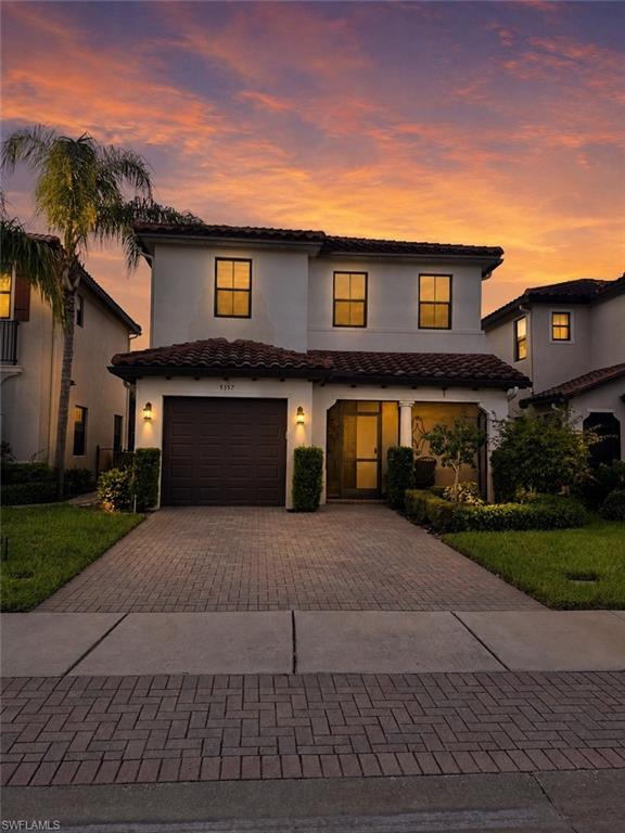 Stucco exterior with a tile roof and integrated garage