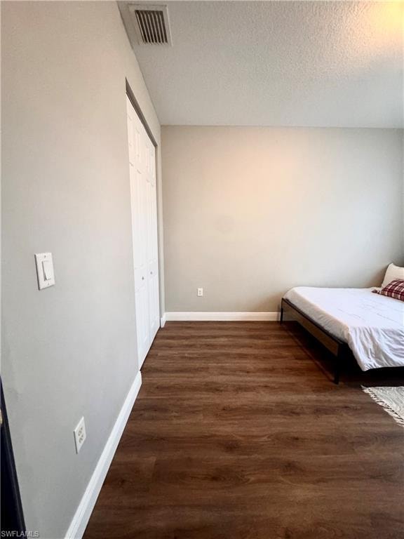 Room featuring wood-finish flooring, light gray wall paint, and white baseboards