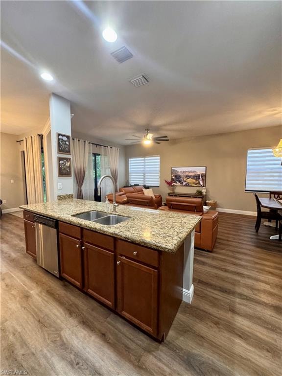 Central kitchen island featuring a double-basin sink and stainless-steel dishwasher