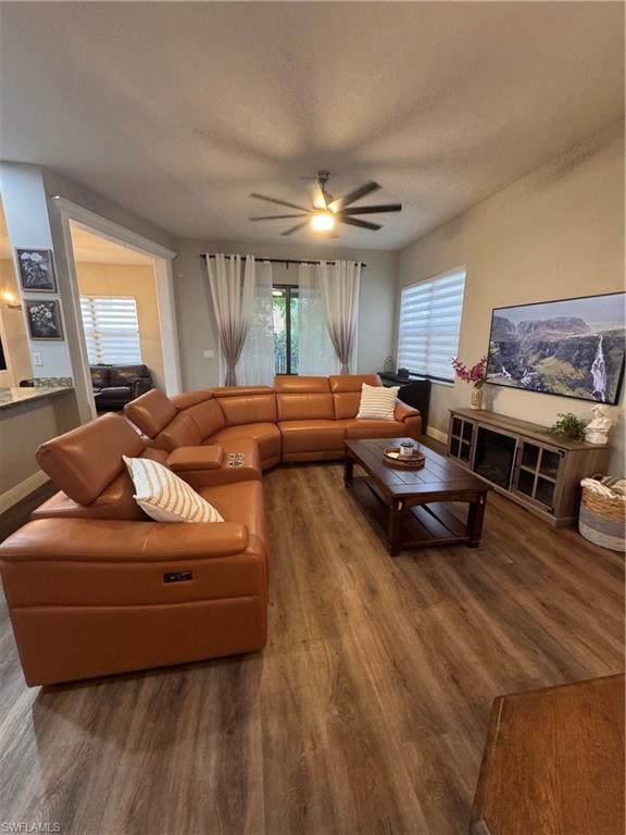 Expansive living area featuring wood-finish flooring and a ceiling fan