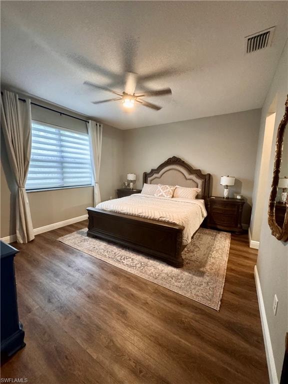 Spacious room featuring wood-finish flooring, a ceiling fan with integrated lighting, and neutral wall tones