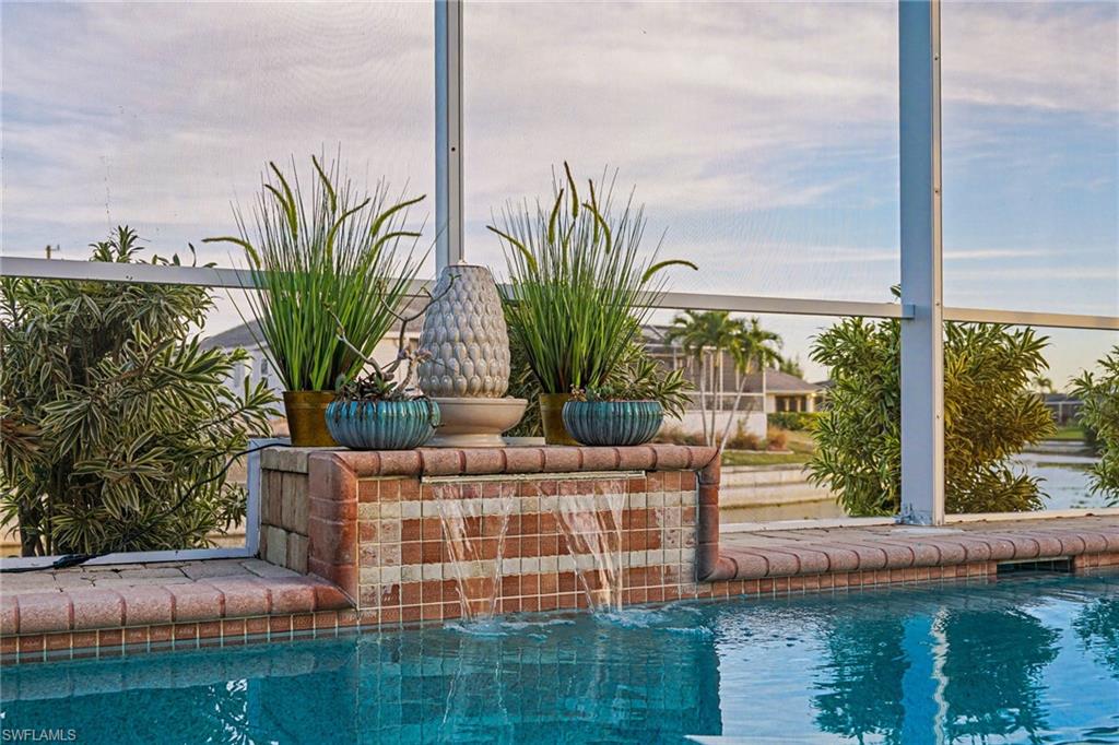 Water feature with brick and mosaic tile detailing, integrated into the pool deck