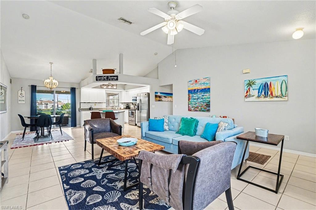 Open-concept living space featuring vaulted ceilings, tile flooring, and a ceiling fan