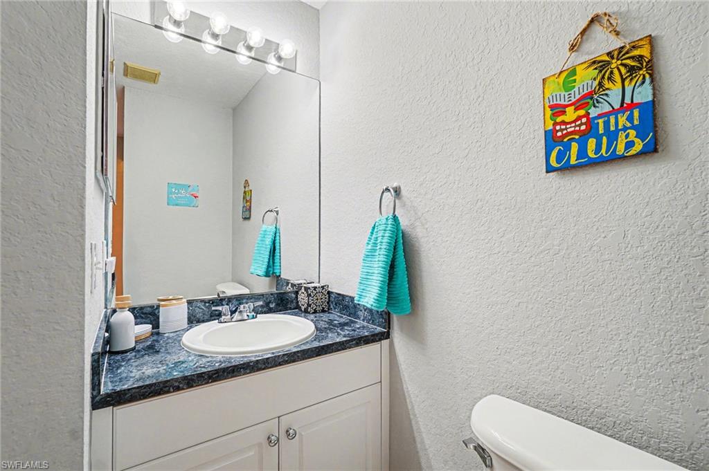 Bathroom vanity featuring a built-in sink, dark mottled countertop, and white cabinetry