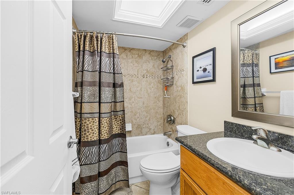 Bathroom featuring a light-toned vanity with a granite-style countertop and an undermount sink