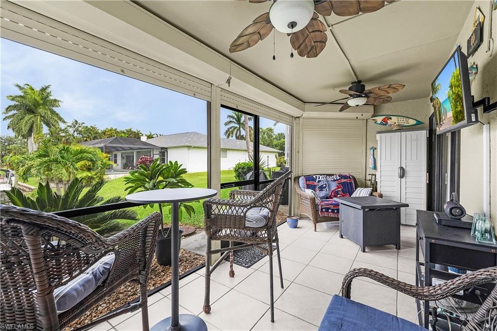 Screened lanai featuring white tile flooring and two ceiling fans