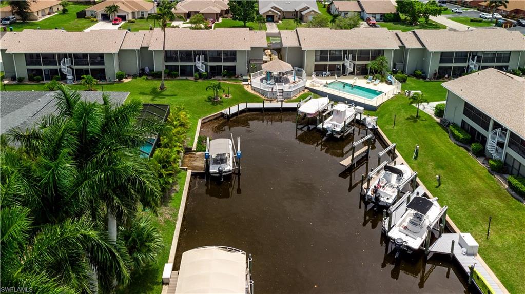 Waterfront property featuring boat docks, a communal swimming pool, and a poolside gazebo