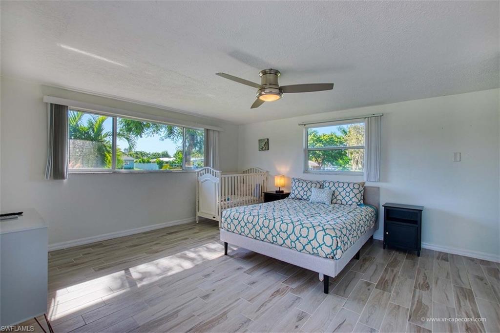 Spacious room featuring wood-finish flooring and a ceiling fan with integrated lighting