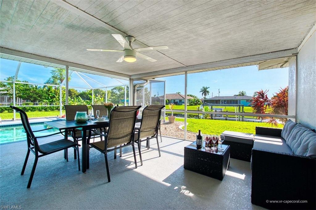 Screened lanai featuring a ceiling fan, direct pool access, and waterfront canal views