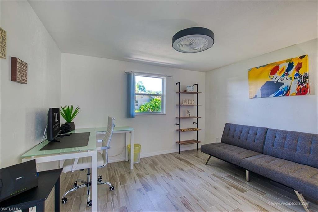 Bright room featuring wood-finish flooring, a contemporary ceiling fan, and a single window with blinds