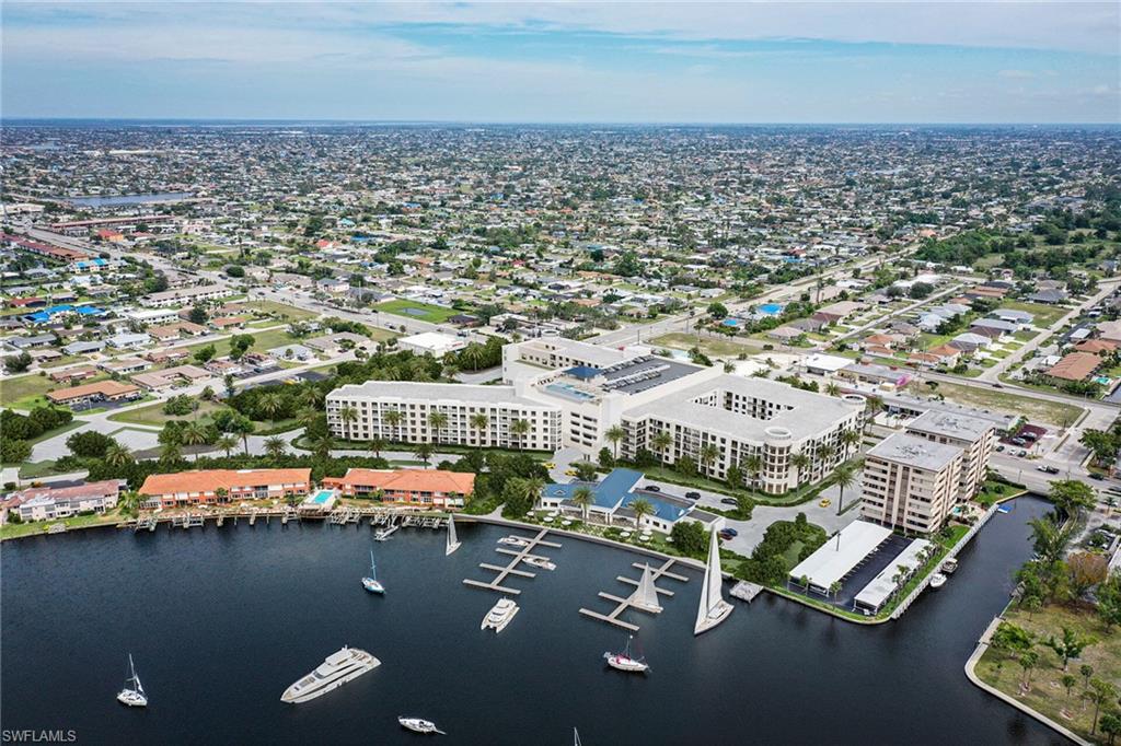 Waterfront property featuring multiple buildings, boat slips, and surrounding urban development