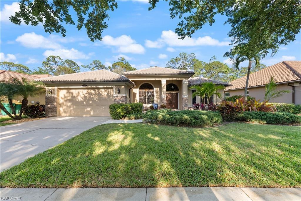 Mediterranean / spanish-style home featuring stucco siding, a front yard, an attached garage, stone siding, and driveway