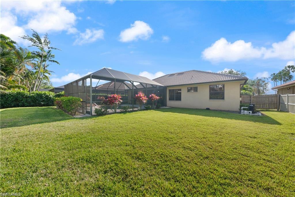 Back of property with a sunroom, a lanai, stucco siding, and a tile roof