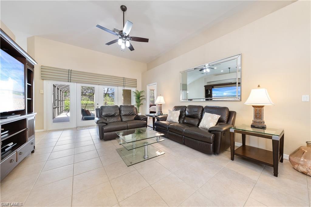 Living room with light tile patterned flooring, french doors, and ceiling fan