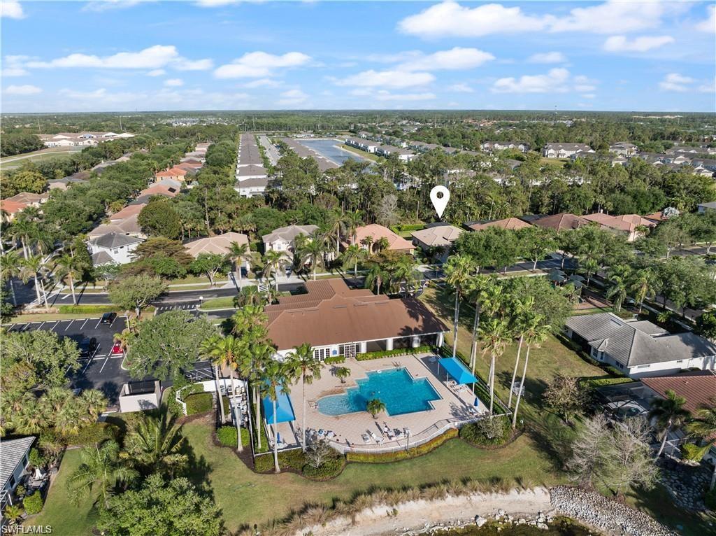 Aerial view of property's location featuring a pool and nearby suburban area