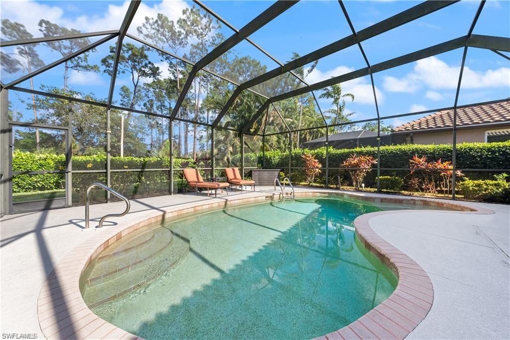 Swimming pool featuring glass enclosure, a sunroom, and a patio area