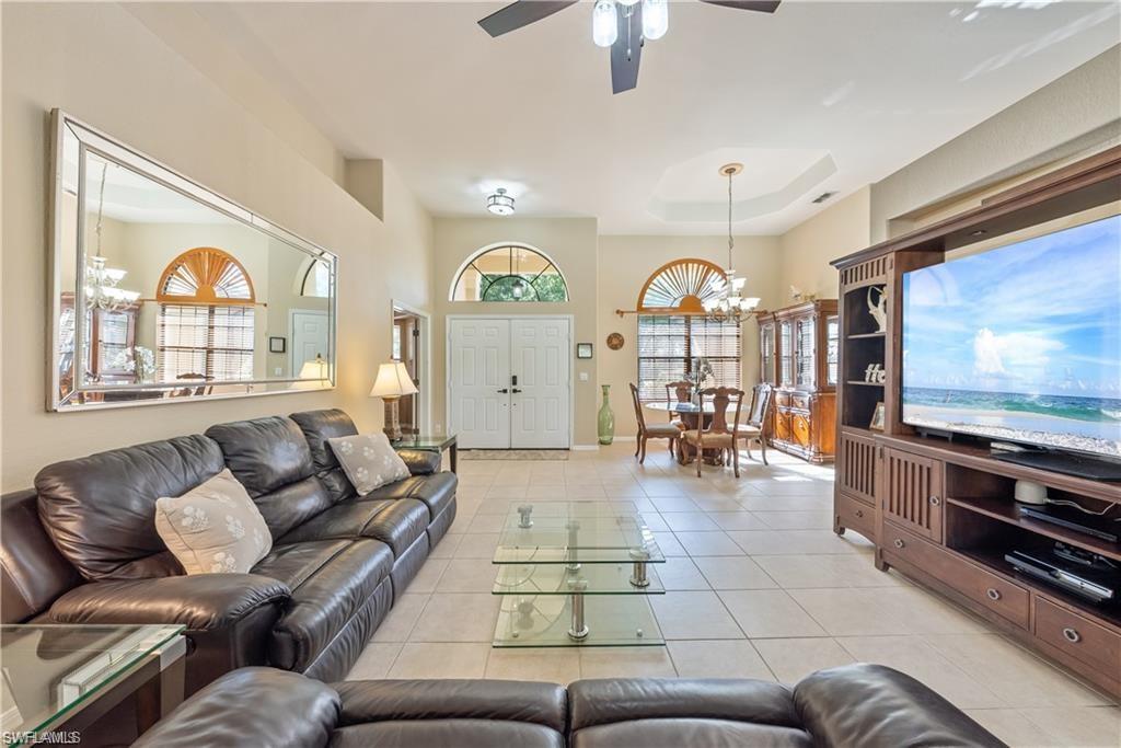 Living area featuring a chandelier, light tile patterned floors, and ceiling fan