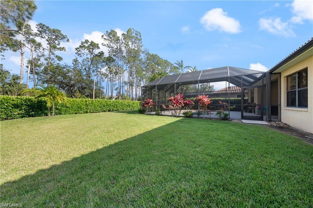 View of green lawn featuring glass enclosure and a sunroom