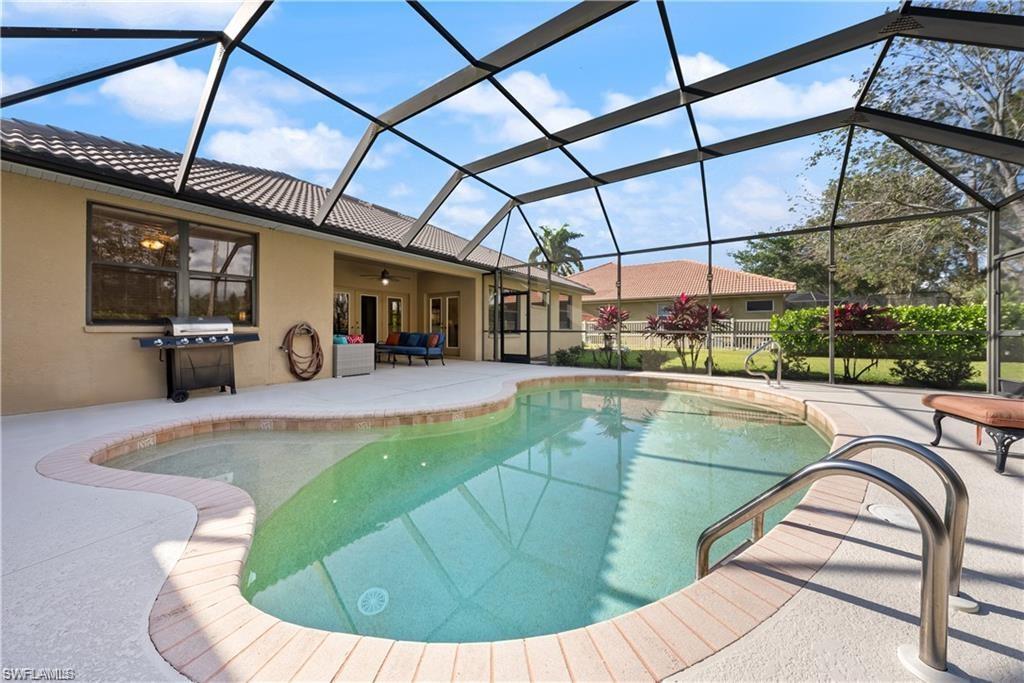 Swimming pool with area for grilling, glass enclosure, a sunroom, ceiling fan, and a patio area