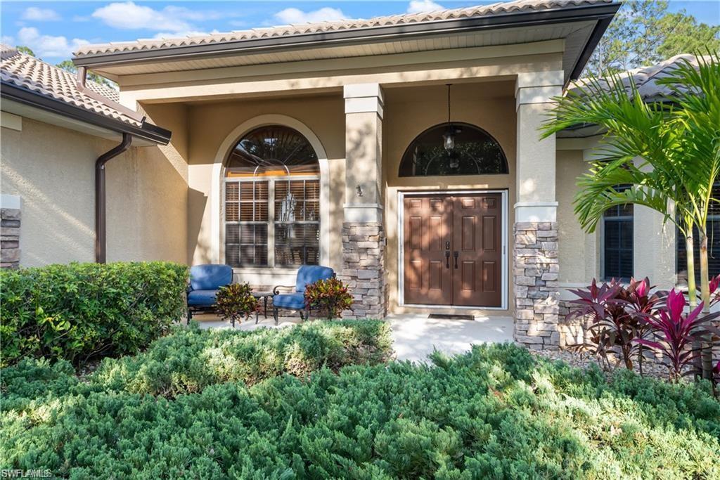 View of exterior entry with stucco siding and stone siding