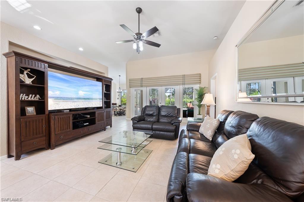 Living area with light tile patterned flooring, a ceiling fan, recessed lighting, and french doors