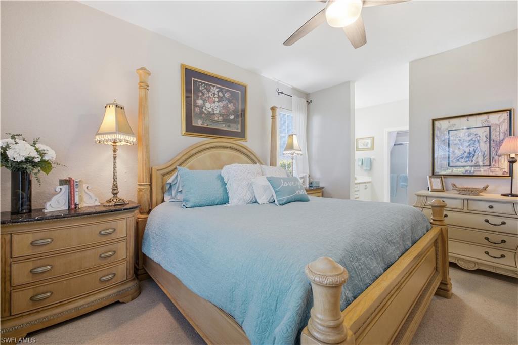 Spacious bedroom featuring light-colored walls and carpet flooring