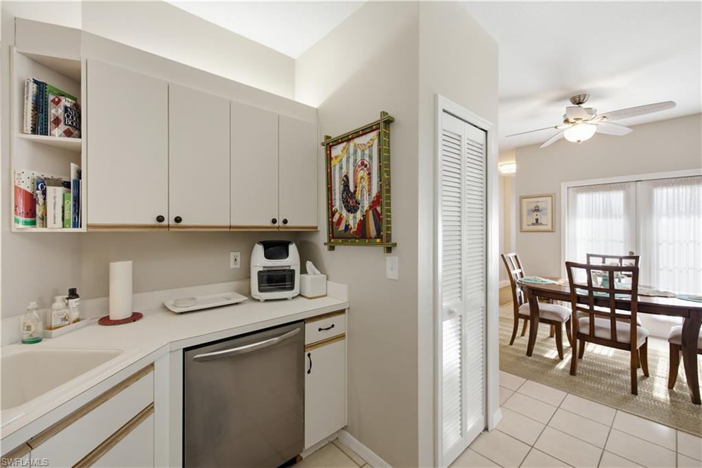 Kitchen area with white cabinetry, light countertops, and a stainless steel dishwasher
