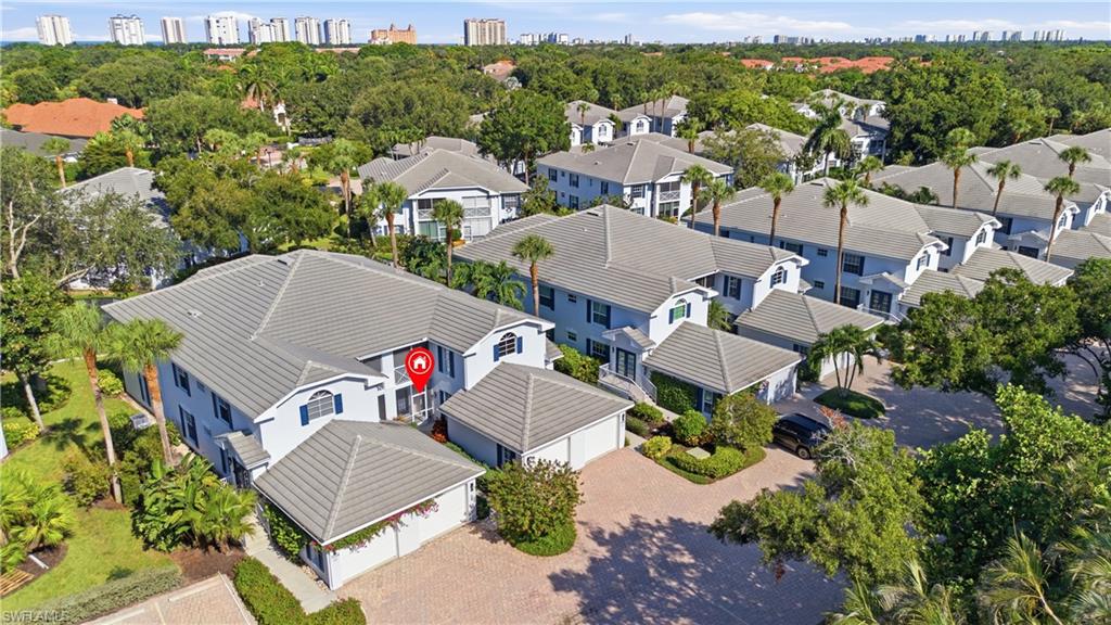 Aerial perspective showcasing a multi-unit property with light-colored siding and gray tile roofing