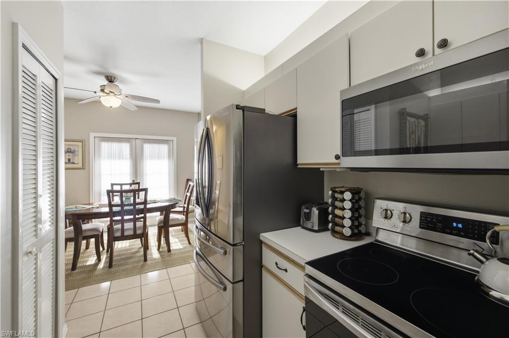 Kitchen featuring stainless steel appliances, light-toned cabinetry, and tile flooring