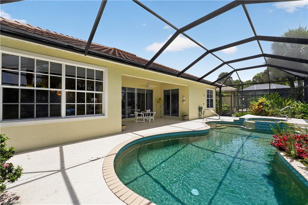 Screen-enclosed curvilinear pool and integrated spa with a tiled spillway