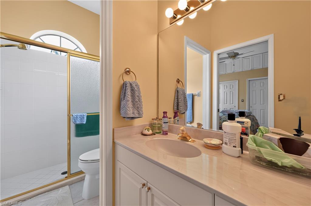 Bathroom featuring a light-toned vanity with an integrated sink and a large wall-mounted mirror