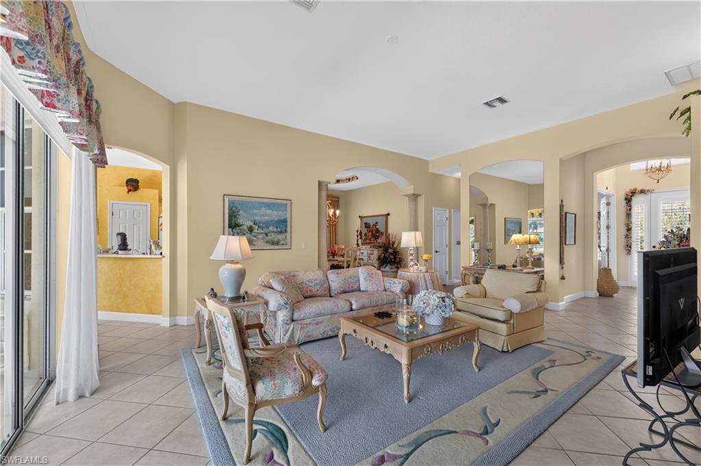 Spacious living area featuring vaulted ceilings, tile flooring, and arched doorways