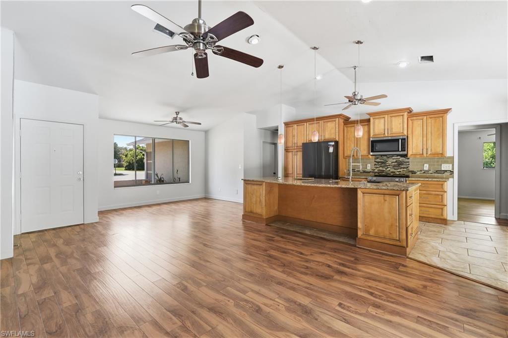 Open-concept kitchen and living area featuring wood-finish flooring