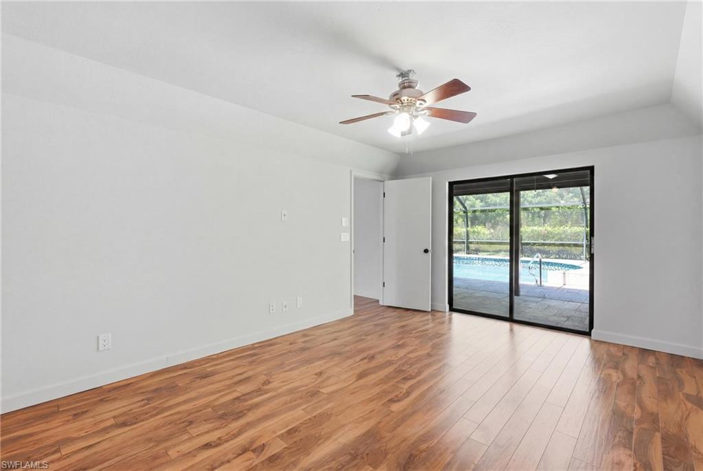 Interior room featuring wood-finish flooring, white walls, and a ceiling fan with integrated lighting
