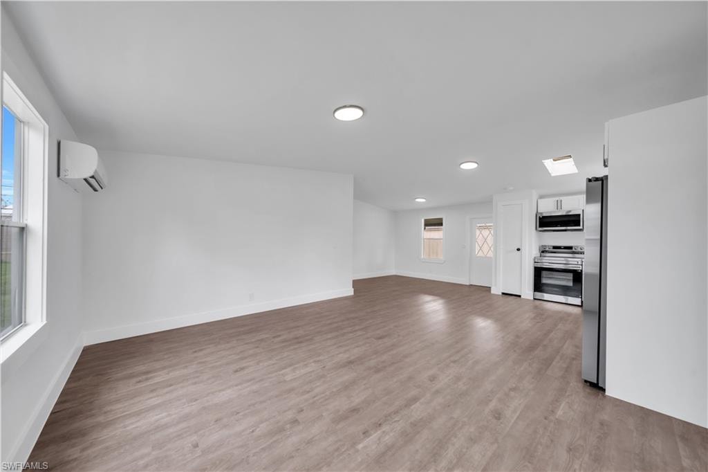 Open-concept living area with wood-finish flooring, recessed lighting, and a ductless mini-split system