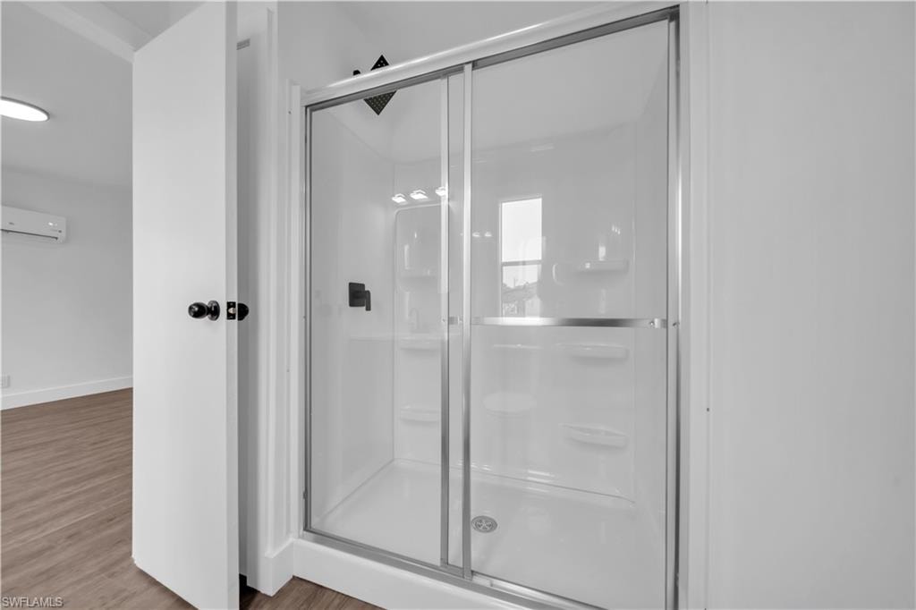 Full standing shower enclosure with sliding glass doors and dark bronze fixtures