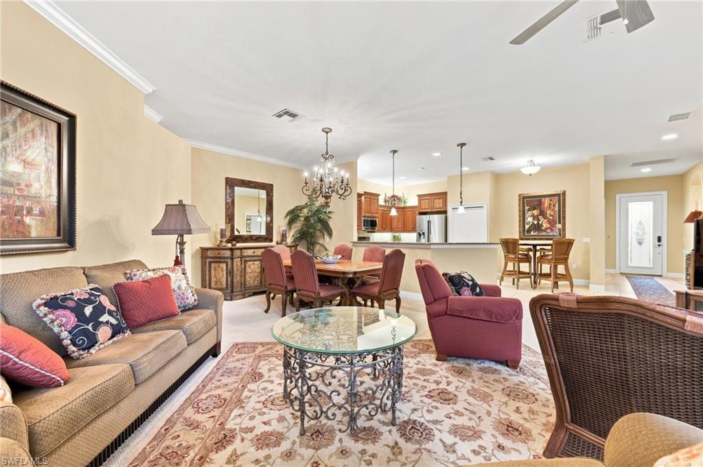 Spacious open-concept living area featuring a cream-toned palette, recessed ceiling lighting, and pendant fixtures