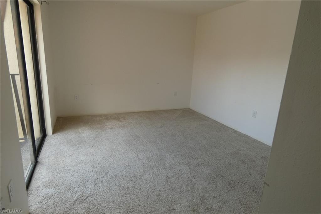 Bright room featuring neutral wall finishes and light-toned carpeting