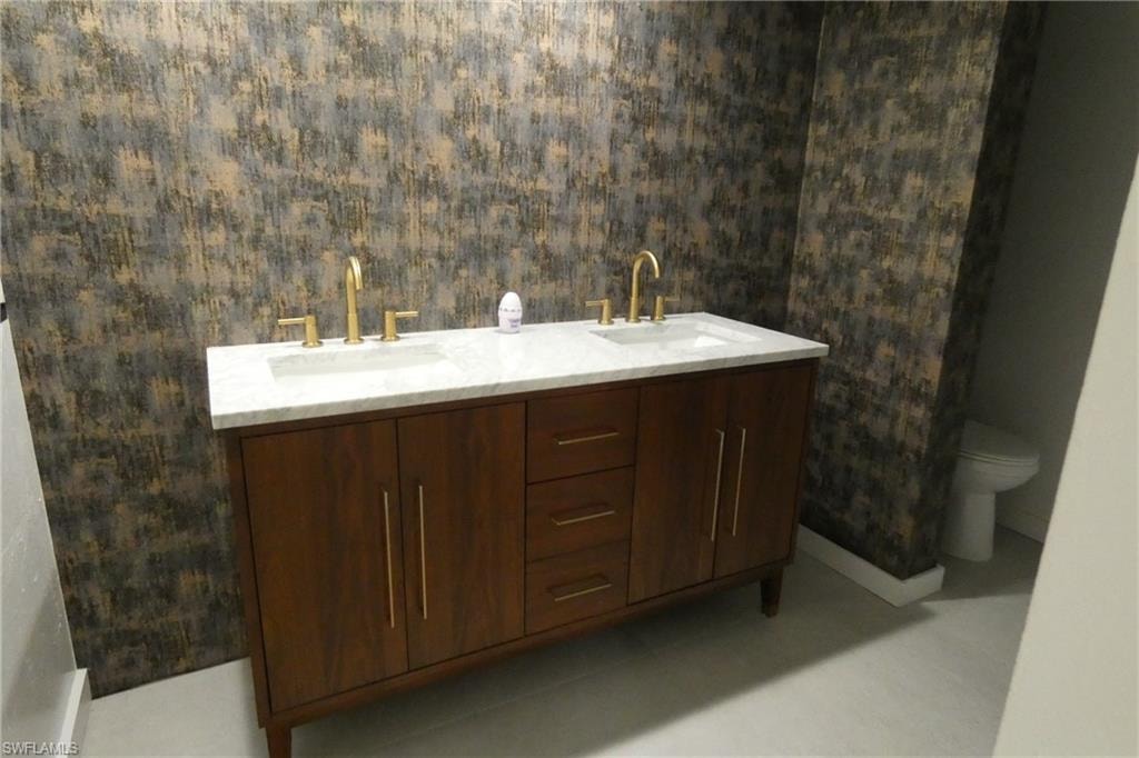 Dual vanity featuring a wood-finish cabinet, gold-tone hardware, and a white countertop