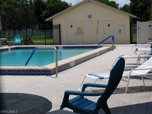 Outdoor swimming pool featuring a patterned tile border and depth markers