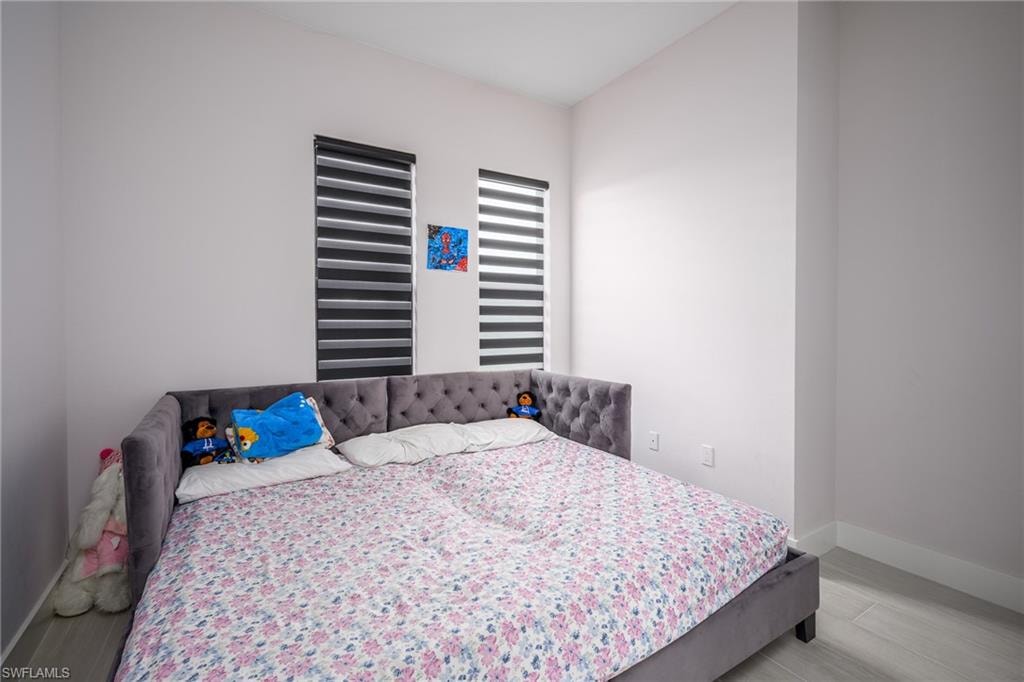 Neutral wall finishes with contemporary window treatments and wood-finish flooring